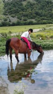 une femme faisant de l'équitation dans l'eau dans l'établissement Il Borgo della Zittola, à Montenero Val Cocchiara