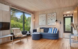 a living room with a blue couch and a tv at 3 Bedroom Stunning Home In Jægerspris in Jægerspris