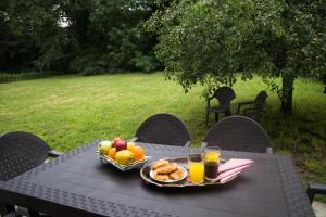 a picnic table with a bowl of fruit and glasses of orange juice at LA CASA DEL RÍO - A 13 kilómetros de Santiago in Sigüeiro