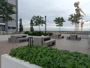 a group of benches and plants in front of a building at Aisy Homestay Putrajaya Cyberjaya KLIA in Kampung Dengkil