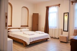 a bedroom with a bed with white sheets and a window at İlçayto Suites in Foça