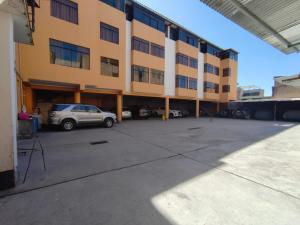 a building with a car parked in a parking lot at Hostal Roma in Ayacucho