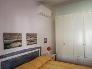 um quarto com uma cama e algumas fotografias na parede em La Sima villa con piscina vista mare San Pantaleo Sardegna em San Pantaleo