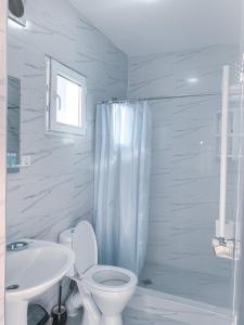 a white bathroom with a toilet and a sink at Family hotel mountain panorama in Borjomi