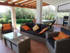 a patio with a couch and chairs and a table at La Sima villa con piscina vista mare San Pantaleo Sardegna in San Pantaleo