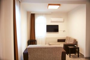 a hotel room with a bed and a chair and a television at İlçayto Suites in Foça