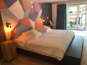 a bedroom with a bed with a geometric wall at Hotel La Librairie in Durbuy