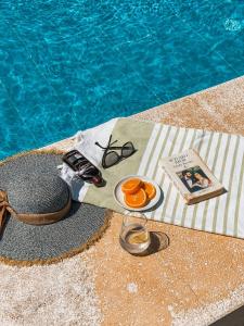 a table with a plate of oranges next to a swimming pool at İlçayto Suites in Foça