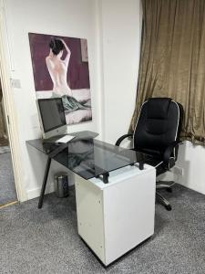Super spacious, Grnd Floor Flat في لندن: مكتب مع جهاز كمبيوتر وكرسي في الغرفة