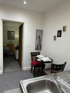 a kitchen with a sink and a table with chairs at Super spacious, Grnd Floor Flat in London