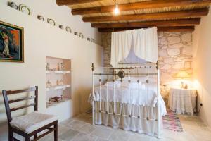 a bedroom with a bed and a chair in a room at Olympia Traditional Houses in Lymbia