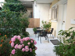 a patio with a table and chairs and flowers at Veatriki Lefkada in Lefkada