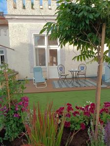 a patio with a table and chairs and flowers at Leier apartments in Piešťany