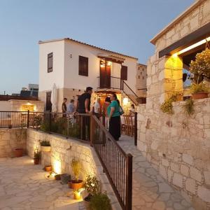 a group of people standing on a balcony of a building at Olympia Traditional Houses in Lymbia