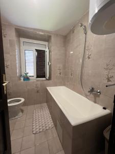 a bathroom with a tub and a toilet and a sink at City life apartman in Herceg-Novi +20 photos