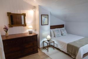 a bedroom with a bed and a dresser with two lamps at Casa das Marés 2 in Baleal