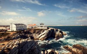 un grupo de edificios en la cima de una isla rocosa en el océano en Casa das Marés 2 en Baleal