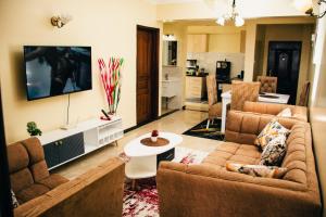 een woonkamer met 2 banken en een tafel bij Furnished 2 bedroom apartment in Kilimani in Nairobi