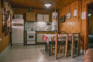 uma cozinha com uma mesa e um frigorífico branco em CABAÑAS DE CHACRAS em Ciudad Lujan de Cuyo