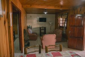 ein Wohnzimmer mit einem Sofa und einem Stuhl in der Unterkunft CABAÑAS DE CHACRAS in Ciudad Lujan de Cuyo