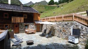 an outdoor patio with a stone wall and a fireplace at Bergchalet Englhof in Moso