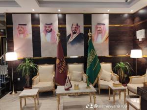 a lobby with chairs and a large wall with portraits at ليالي العاذريه للشقق المخدومة in Al Namas