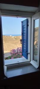 an open window with a view of the beach at Kioura's home in Ano Syros
