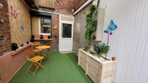 a small patio with a table and chairs on it at Studio Design Cocon SPA privé à deux pas de Lille in La Bassée