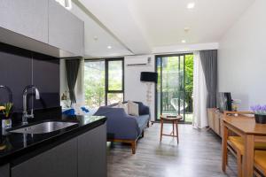 a kitchen with a sink and a living room at The deck condominium by Ryan, walking to patong beach in Patong Beach