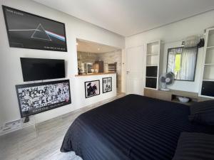 - une chambre avec un lit et une télévision à écran plat dans l'établissement Le 7, à Capbreton