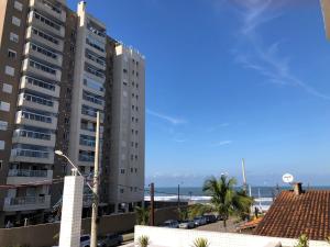 a tall building with the ocean in the background at Itanhaém Praia & Mar in Itanhaém