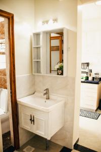 een badkamer met een witte wastafel en een spiegel bij Furnished 2 bedroom apartment in Kilimani in Nairobi