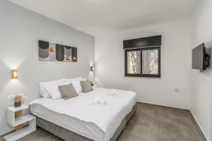 a white bedroom with a bed and a window at New Luxury 3 BR - Next the Orient Hotel in Jerusalem