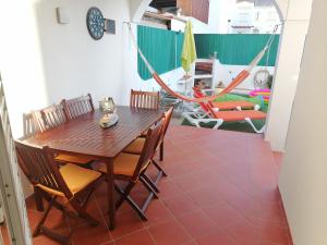 una sala da pranzo con tavolo, sedie e amaca di Marreiro's house Algarve - Child friendy - Private Pool a Lagos