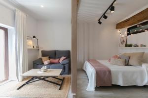 ein Schlafzimmer mit einem Sofa, einem Bett und einem Tisch in der Unterkunft DuermeCuenca in Cuenca