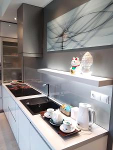 a kitchen with a sink and a stove top oven at Apartament City Center JAPAN - no smoking, free bottled water, coffea and tea in Koszalin