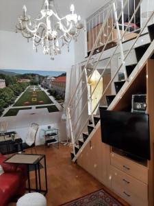 un salon avec un lustre et un grand escalier dans l'établissement VILLA GOLF Crystal Drop Apartment, à Rogaška Slatina