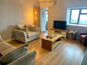 a living room with a couch and a tv at Welsh cottage coastal retreat with stunning views in Pen-y-groes