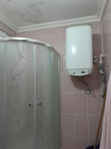 La salle de bains est pourvue d'une douche et d'une porte en verre. dans l'établissement Doğa manzaralı ev, 