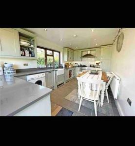 a large kitchen with a table and chairs in it at Welsh cottage coastal retreat with stunning views in Pen-y-groes