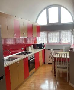uma cozinha com armários coloridos, uma mesa e cadeiras em Zen Apartment em Sighetu Marmaţiei