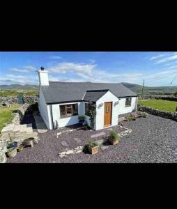 a small white house with a stone yard at Welsh cottage coastal retreat with stunning views in Pen-y-groes