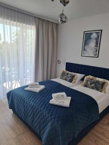 SOLEK Apartamenty i pokoje gościnne في ميلنو: غرفة نوم عليها سرير وفوط