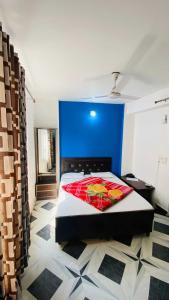 1 dormitorio con 1 cama grande y pared azul en OYO Flagship 12976 Hotel New Fiza, en Jammu