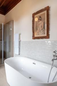 un bagno con vasca e foto appese alla parete di Chalet Ficalho a Cascais