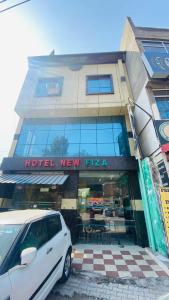 a white car parked in front of a hotel new pizza at OYO Flagship 12976 Hotel New Fiza in Jammu