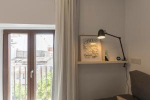 ein Wohnzimmer mit einem Fenster und einer Lampe in der Unterkunft DuermeCuenca in Cuenca