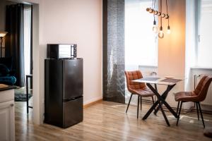 a kitchen with a refrigerator and a table with chairs at Modernes Apartment in Sulz am Neckar