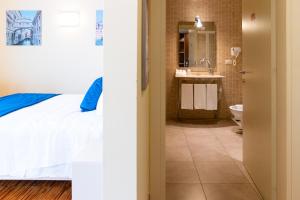 a bedroom with a bed and a bathroom with a sink at Hotel Autoespresso Venice - Atika & Atif in Marghera