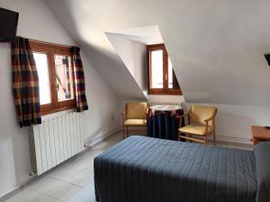 - une chambre avec un lit, une table et des chaises dans l'établissement HOTEL FAMILIAR MAXIMINA, à Sallent de Gállego